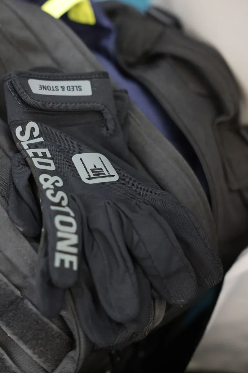 The Sled & Stone glove on a race bag at HYROX Salt Lake City, wordmark down the fingers and the sled mark on the back of the hand