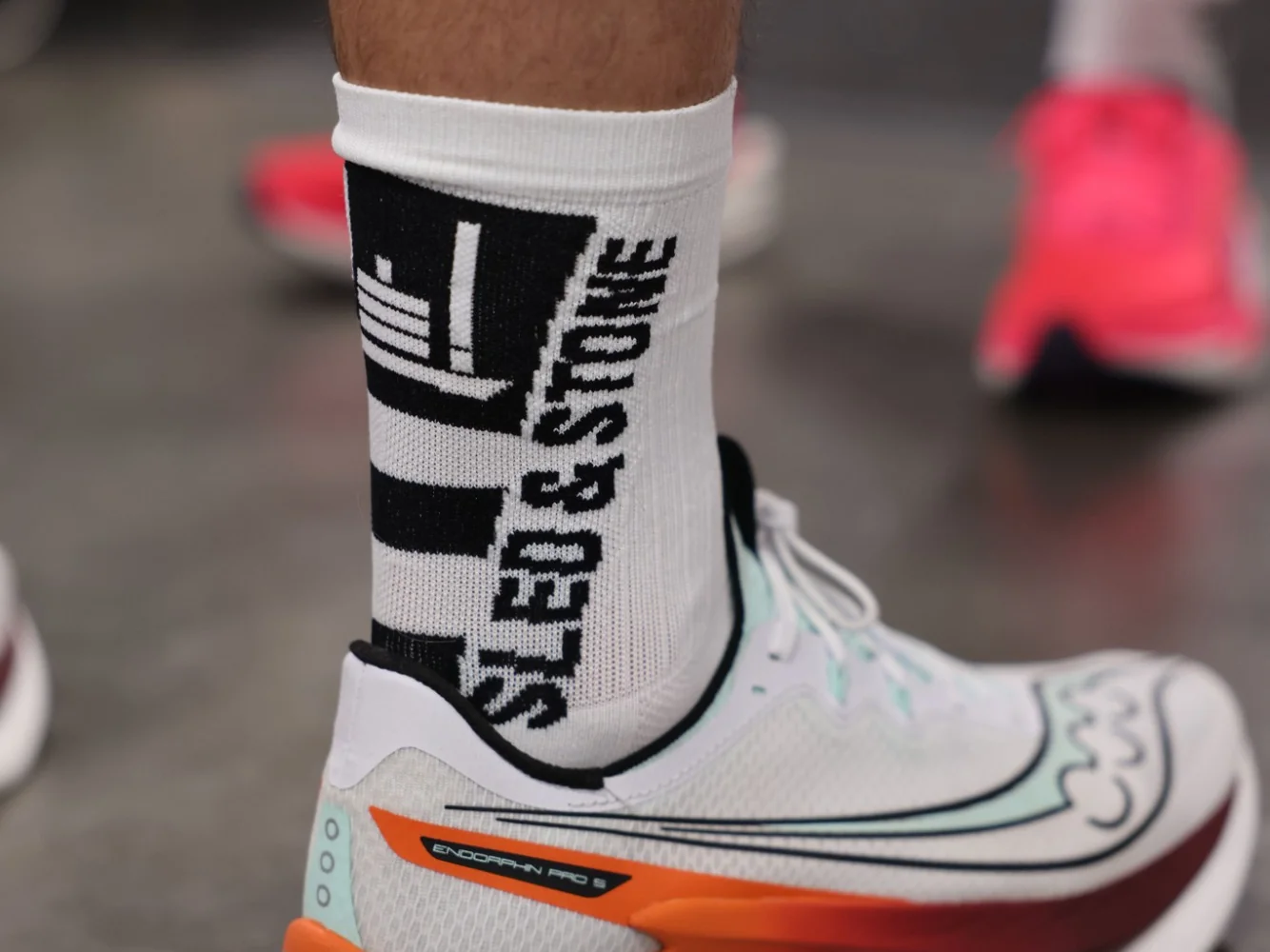 The Updraft race sock in white with black, Sled & Stone knitted down the cuff — view 3