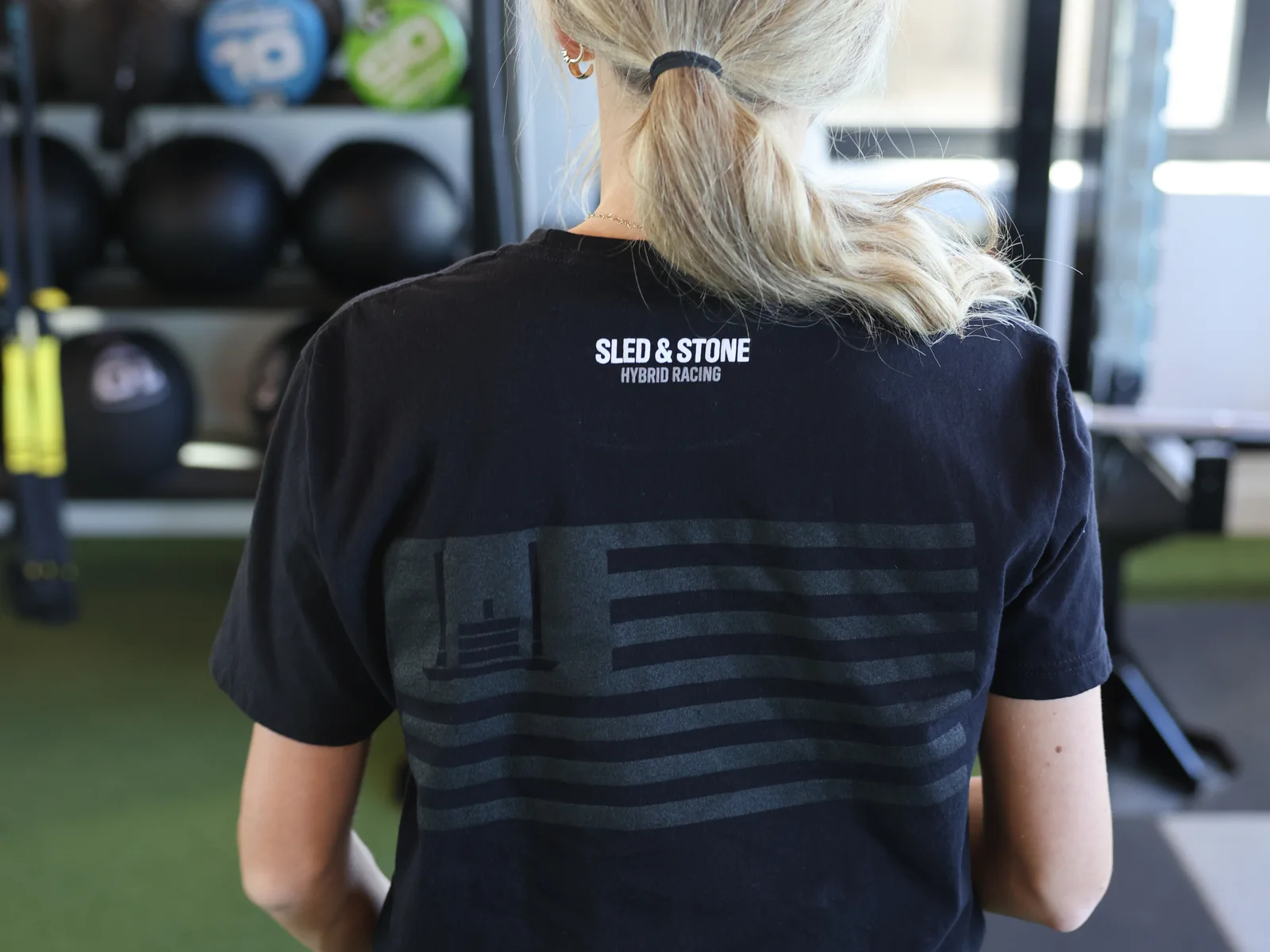 The Grip Wins Races tee in black and sand, worn side by side: Sled & Stone across the chest over Grip Wins Races — view 4