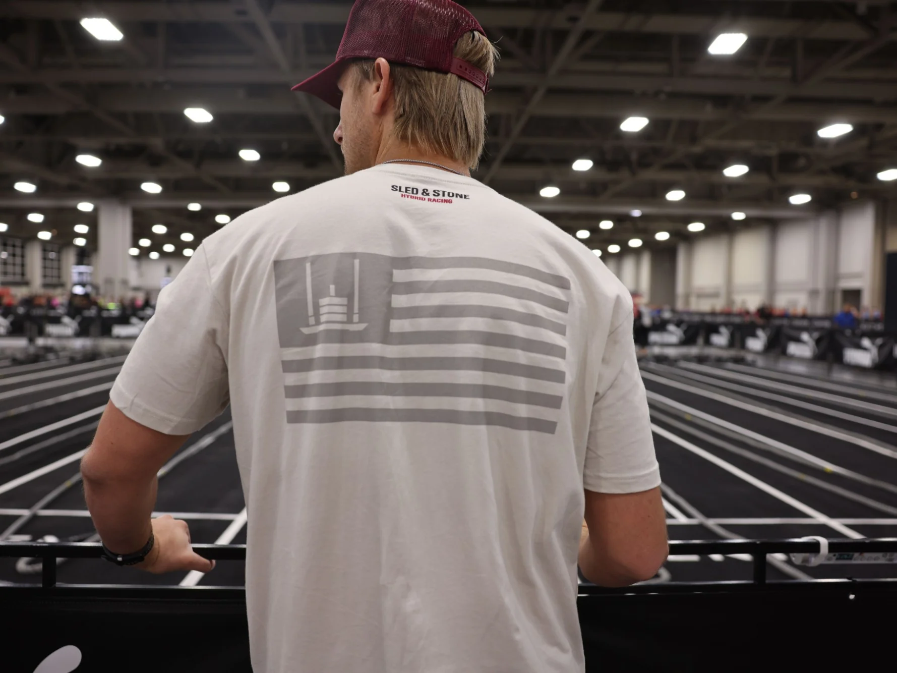 The Grip Wins Races tee in black and sand, worn side by side: Sled & Stone across the chest over Grip Wins Races — view 3